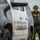 CBP Support to Super Bowl LIV A U.S. Border Patrol Federal Agent in full tactical gear stands near a county sheriff's vehicle. The agent is wearing an olive green uniform with a boonie hat, body armor vest, and a visible badge identifying him as a Border Patrol Federal Agent. The scene appears to be an outdoor law enforcement operation, likely near a border area.