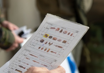 A Peshmerga soldier studies various types of unexploded ordnance