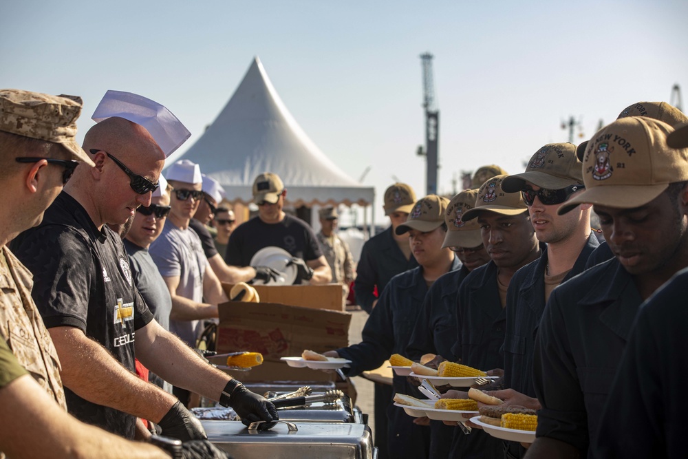 Sailors and Marines take part in a cook out on the pier