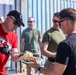 Sailors and Marines take part in a cook out on the pier