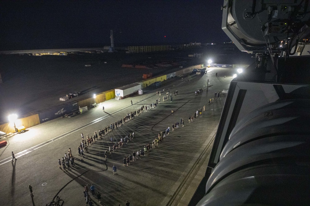 Sailors and Marines take part in a cook out on the pier