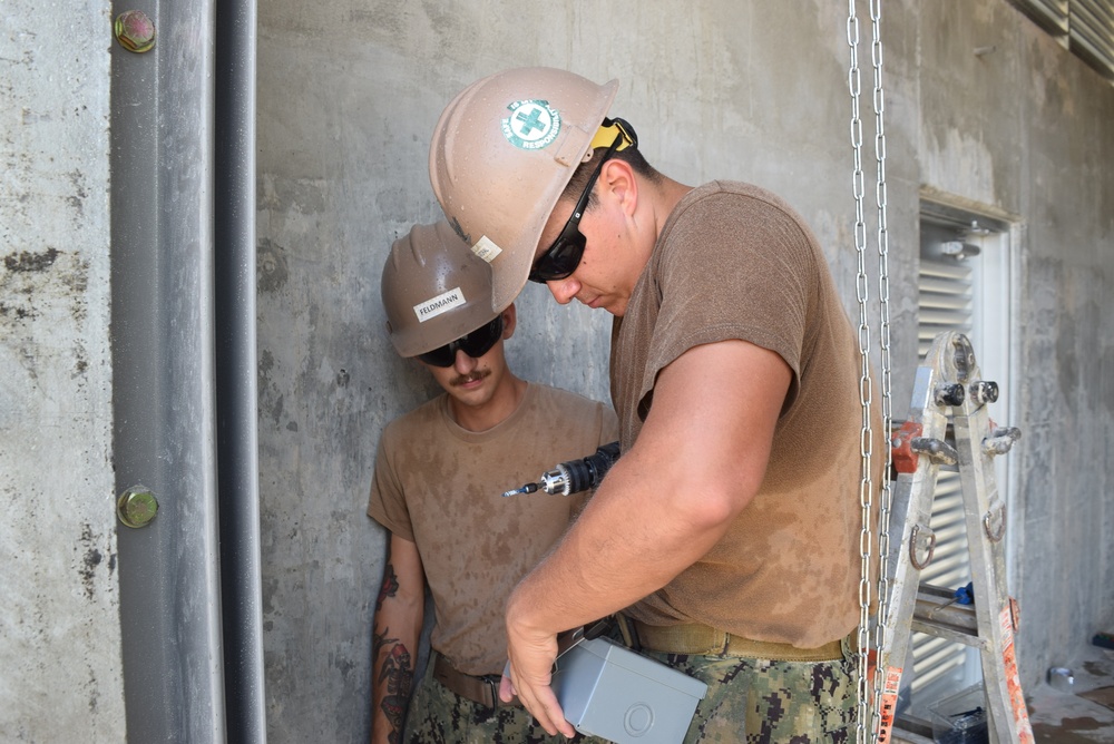 U.S. Navy Seabees with NMCB-5’s Detail Tinian continue work on Explosive Ordnance Disposal Mobile Unit 5’s Boat Storage Facility