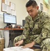 Logistics Specialist Seaman Keith Amarillo places barcodes on packages at the post office