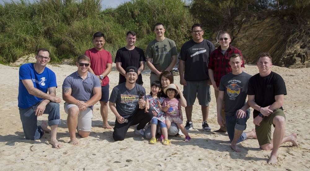 Members of the U.S. military community work with Henoko Senior Citizen’s Association members cleaning up