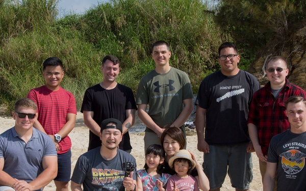 Members of the U.S. military community work with Henoko Senior Citizen’s Association members cleaning up