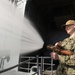 U.S. Navy Electronics Technician Seaman Walton Muller, form Lumberton, North Carolina, conducts fire hose test on the fantail