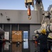 Sailors watch a crane move.