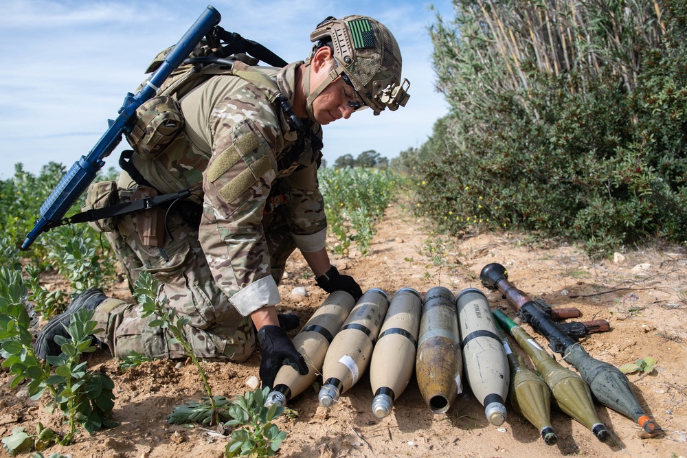 Explosive ordnance technicians conduct a simulated demolition shot, as part of surface cache prosecution training