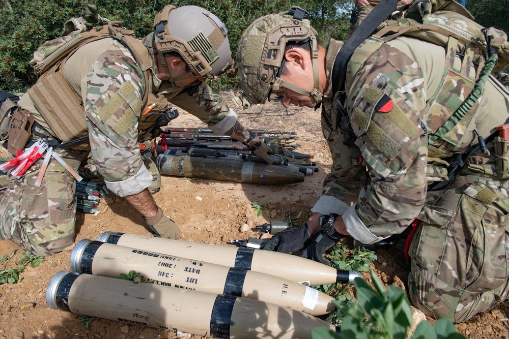 Explosive ordnance technicians conduct a simulated demolition shot, as part of surface cache prosecution training