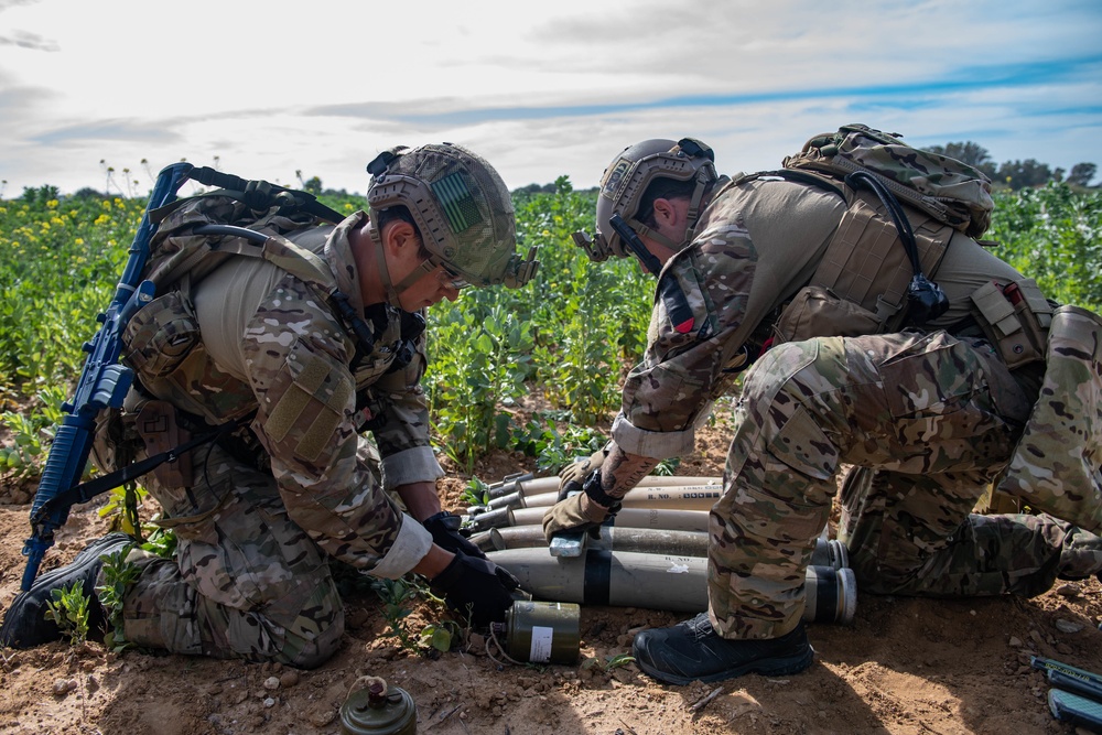 Explosive ordnance technicians conduct a simulated demolition shot, as part of surface cache prosecution training