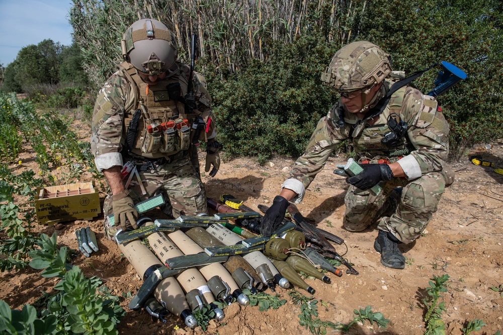 Explosive ordnance technicians conduct a simulated demolition shot, as part of surface cache prosecution training