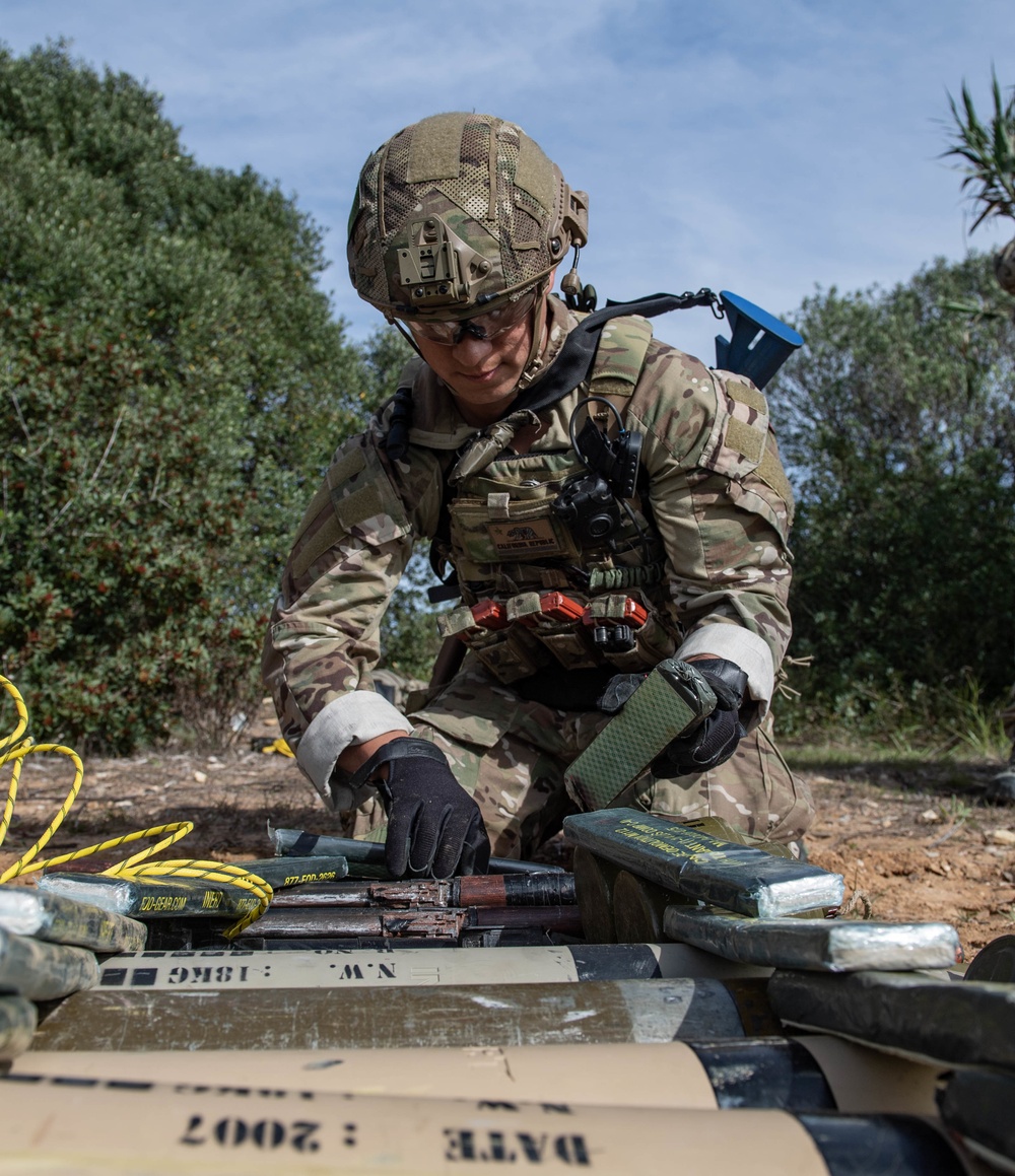 Explosive ordnance technicians conduct a simulated demolition shot, as part of surface cache prosecution training