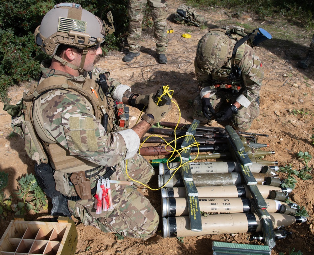 Explosive ordnance technicians conduct a simulated demolition shot, as part of surface cache prosecution training