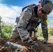 Explosive ordnance technicians conduct a close-range recon of a buried unexploded ordnance (UXO), as part of EOD surface response training