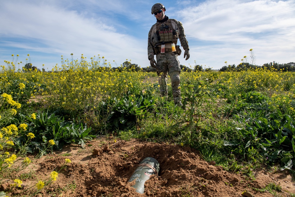 Explosive ordnance technicians conduct a close-range recon of a buried unexploded ordnance (UXO), as part of EOD surface response training