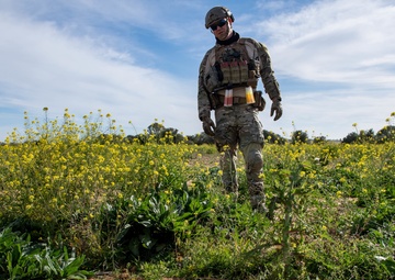 Explosive ordnance technicians conduct a close-range recon of a buried unexploded ordnance (UXO), as part of EOD surface response training