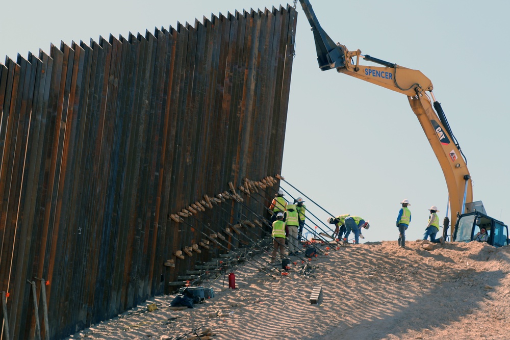 Crews install a 30-foot barrier panel on the side of a hill at Heading Three at the El Centro 1 border barrier location