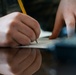Staff Sgt. James Miller makes corrections to a story