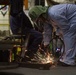 U.S. Navy contractor grinds metal