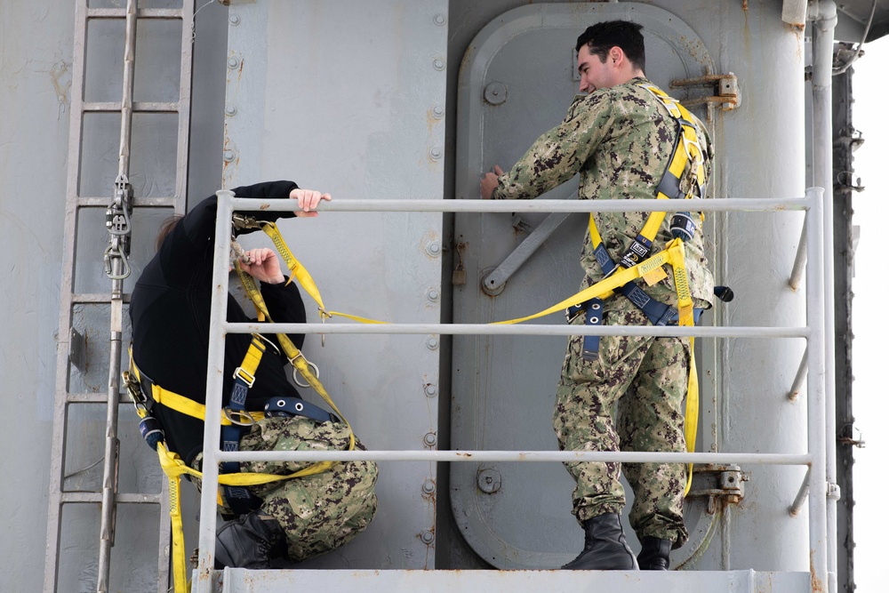 U.S. Sailors work aloft
