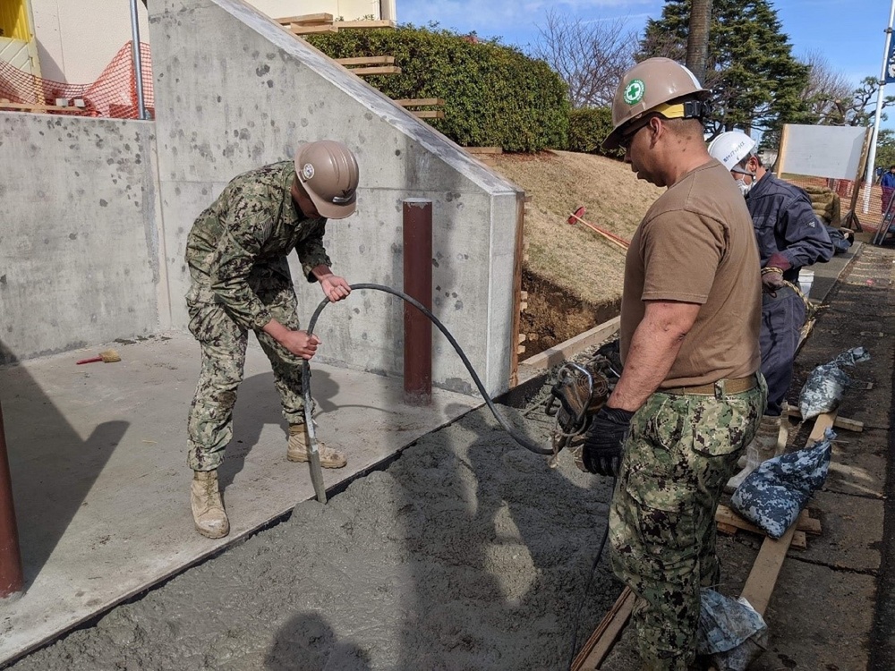 U.S. Navy Seabees with NMCB-5's Detail Atsugi construct a loading dock for the Navy Exchange