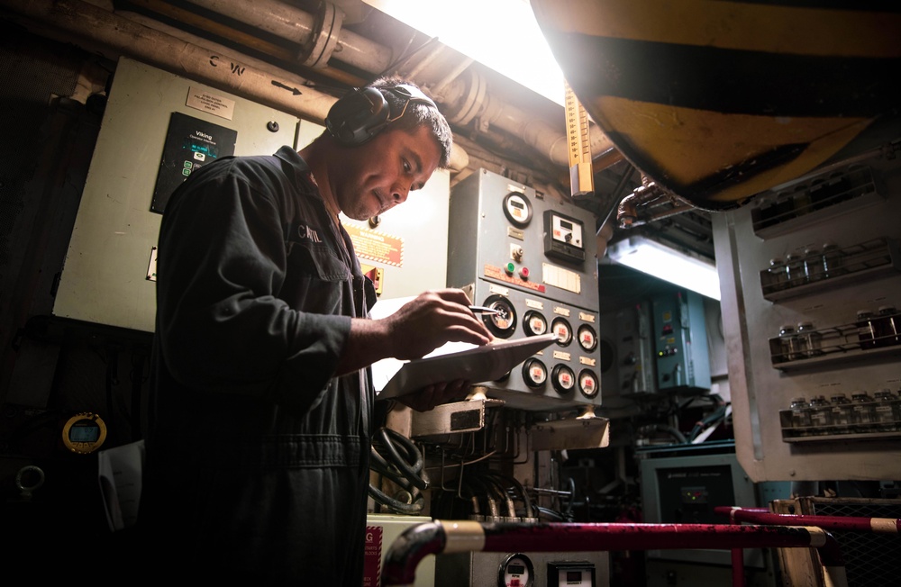 Engineman 2nd Class Ianjames Castil inspects an engine