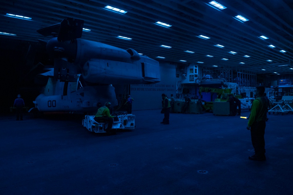 Sailors move aircraft at night.