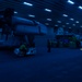 Sailors move aircraft at night.