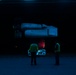 Sailors move aircraft at night.
