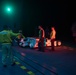 Sailors move aircraft at night.