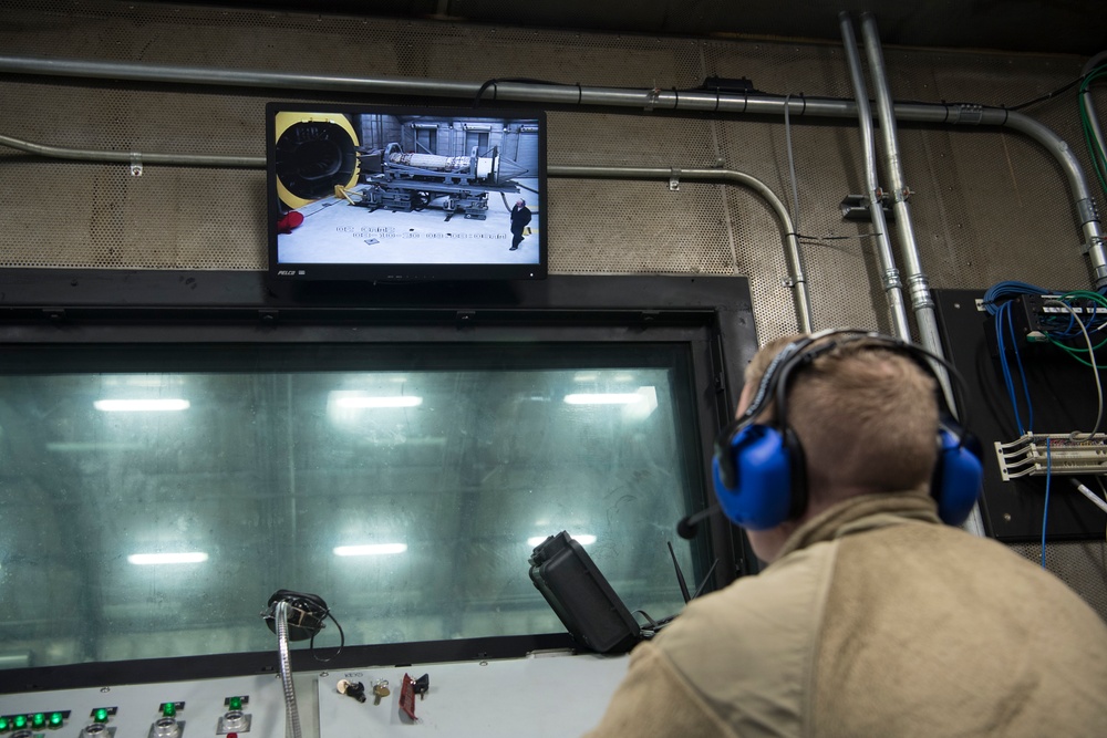 Airmen from the 192nd Wing and 1st Fighter Wing work together in a hush house