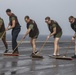 Marines and Sailors aboard the Bataan scrub the flight deck