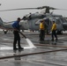 Marines and Sailors aboard the Bataan scrub the flight deck