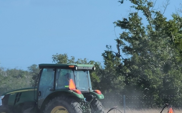 A contractor mows the median between runways