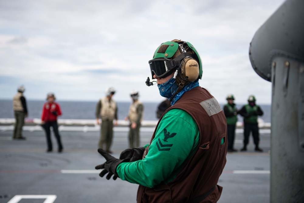 U.S. Sailor prepares to launch an MH-60S Sea Hawk