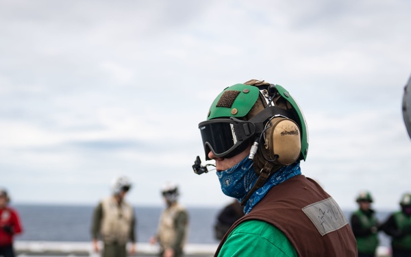 U.S. Sailor prepares to launch an MH-60S Sea Hawk