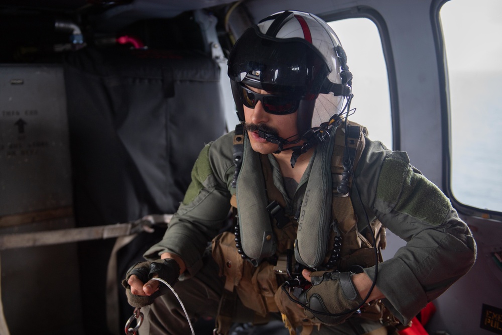 U.S. Sailor performs tasks in MH-60S Sea Hawk