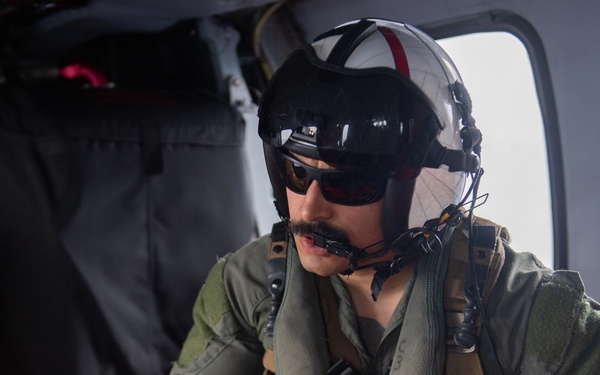 U.S. Sailor performs tasks in MH-60S Sea Hawk