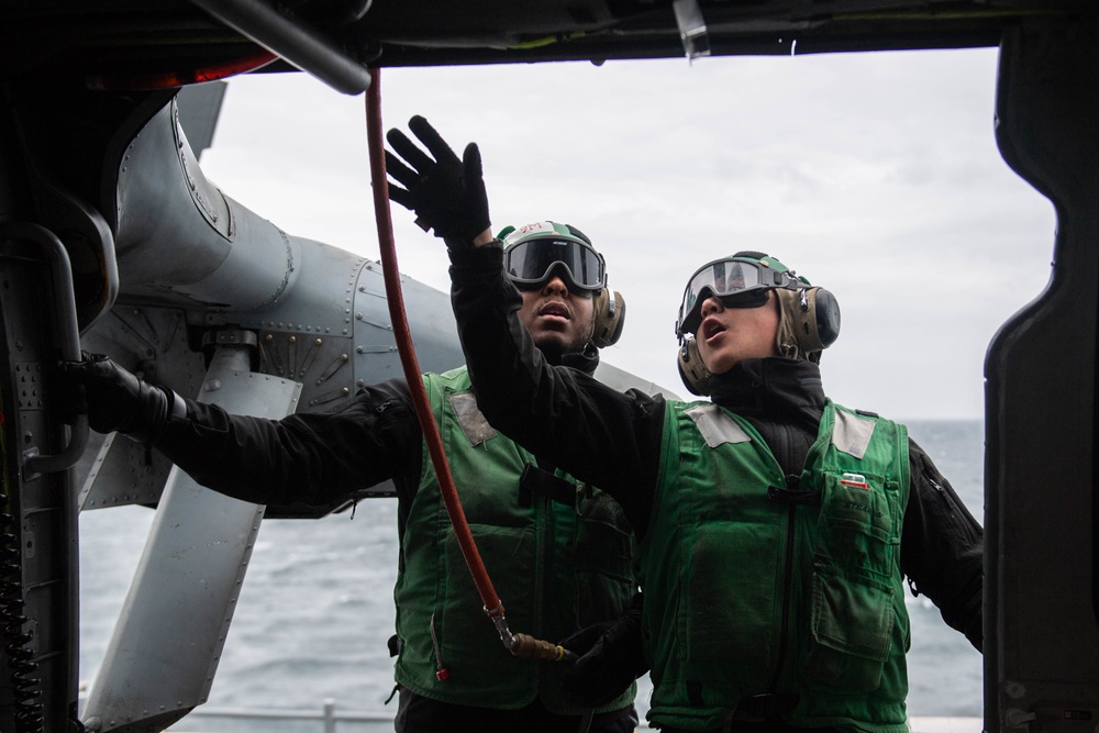 U.S. Sailors perform engine water-wash on MH-60S Sea Hawk