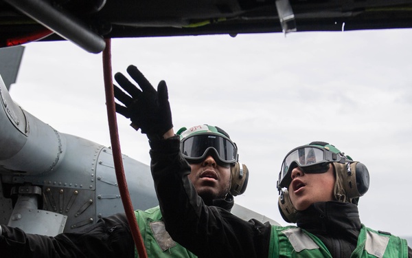 U.S. Sailors perform engine water-wash on MH-60S Sea Hawk