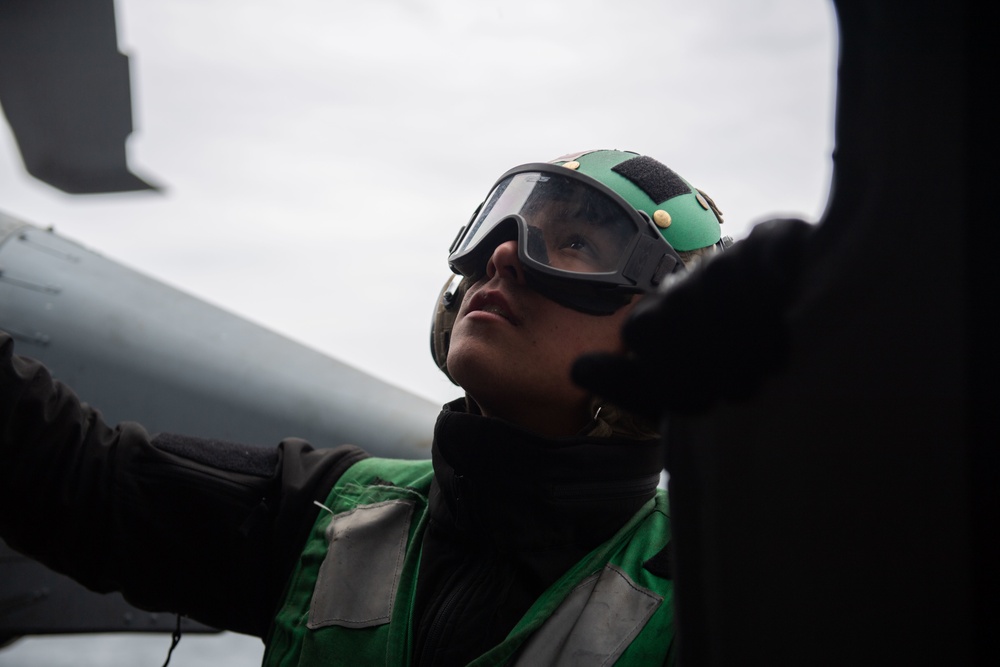 U.S. Sailor performs maintenance on MH-60S Sea Hawk