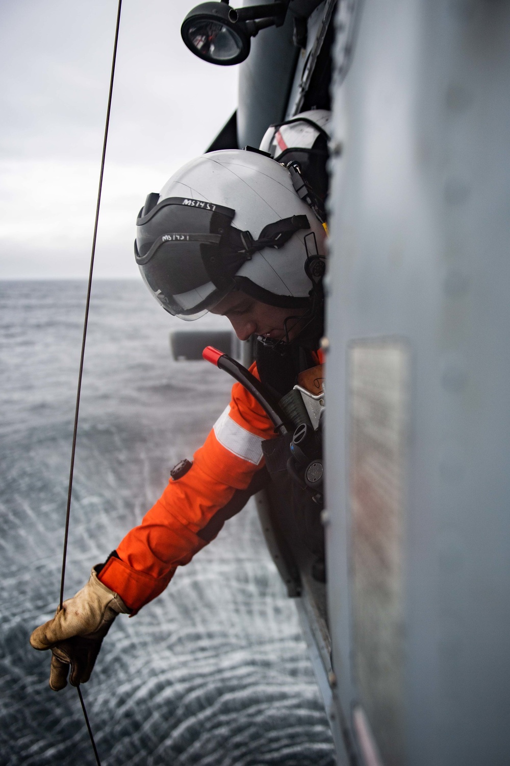 U.S. Sailor lowers hoist from MH-60S Sea Hawk