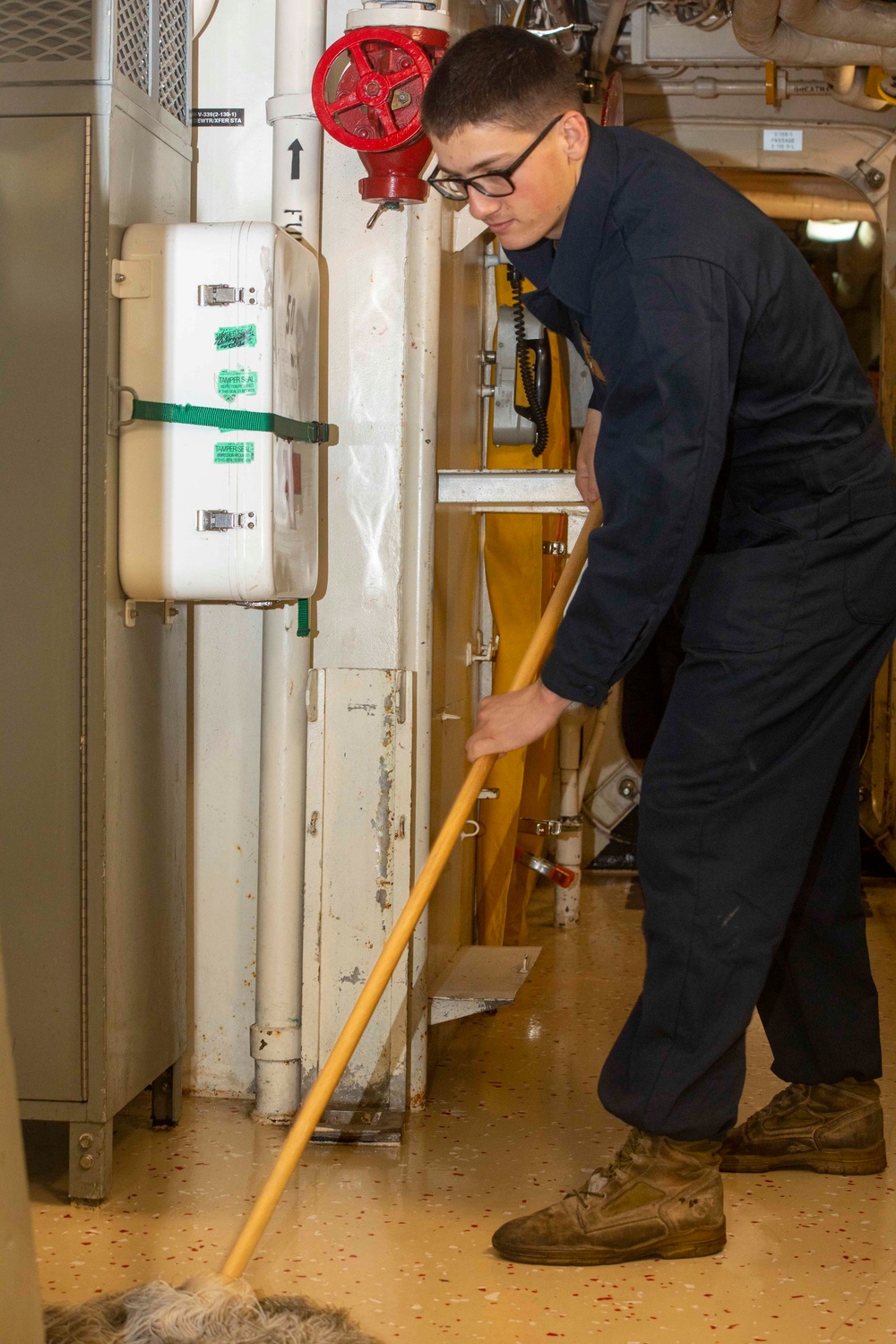 Sailor and Marines clean the ship