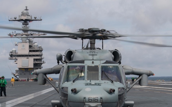 An MH-60S Sea Hawk prepares to take off from the flight deck of the USS Gerald R. Ford
