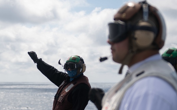 U.S. Sailor gives hand signals to pilots on the flight deck of the aircraft carrier USS Gerald R. Ford