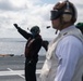 U.S. Sailor gives hand signals to pilots on the flight deck of the aircraft carrier USS Gerald R. Ford