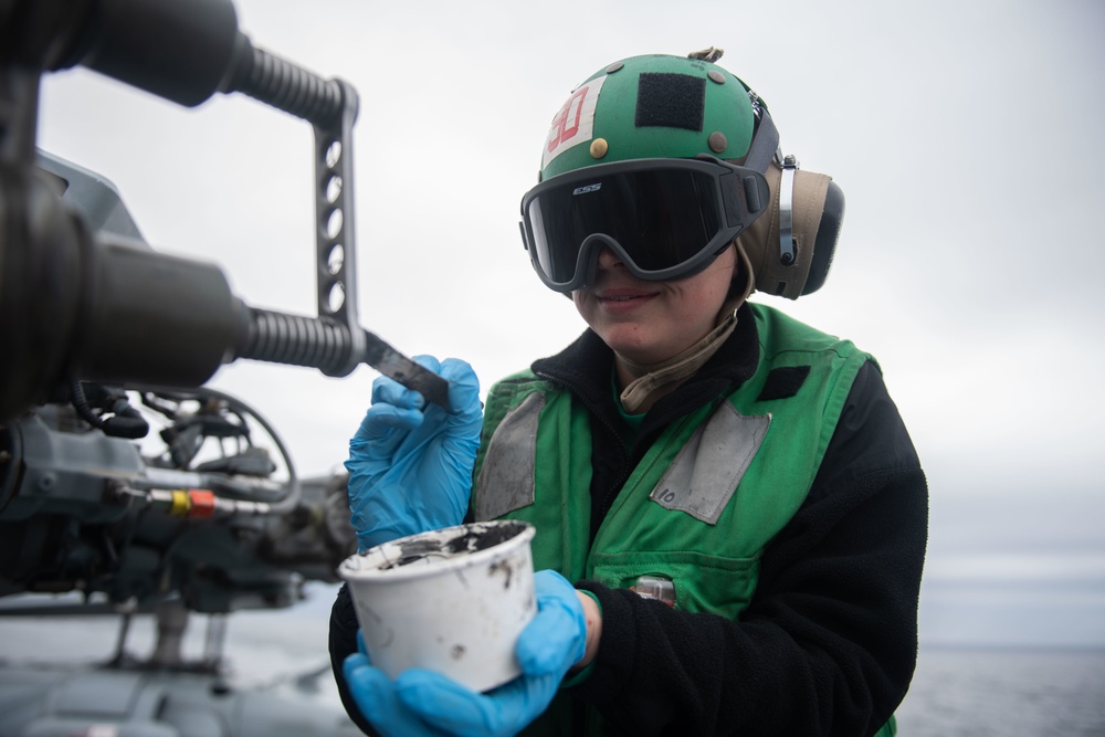 U.S. Sailor performs maintenance on an MH-60S Sea Hawk