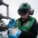 U.S. Sailor performs maintenance on an MH-60S Sea Hawk