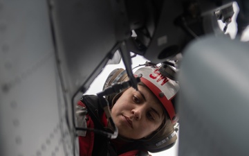 U.S. Sailor performs maintenance on an MH-60S Sea Hawk