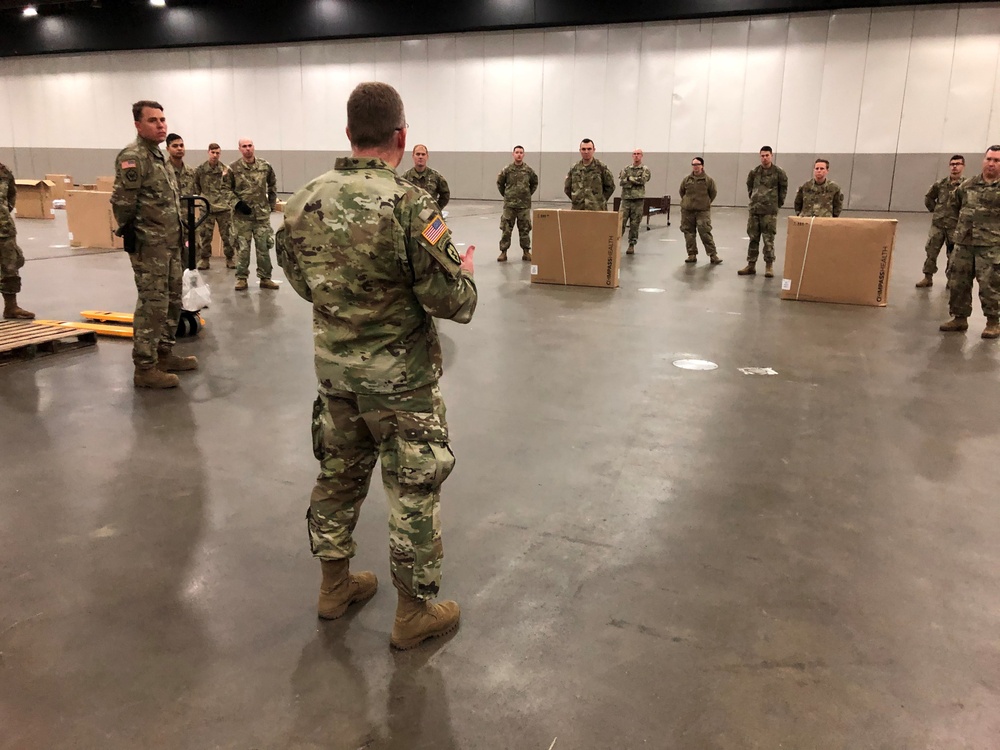 MAJ Robert Mathews, Commander of the 507th EN BN,  briefs members of the 1433 EN CO. on operations at the TCF Center for development of an alternate care facility for the state of Michigan. On 01 April 2020